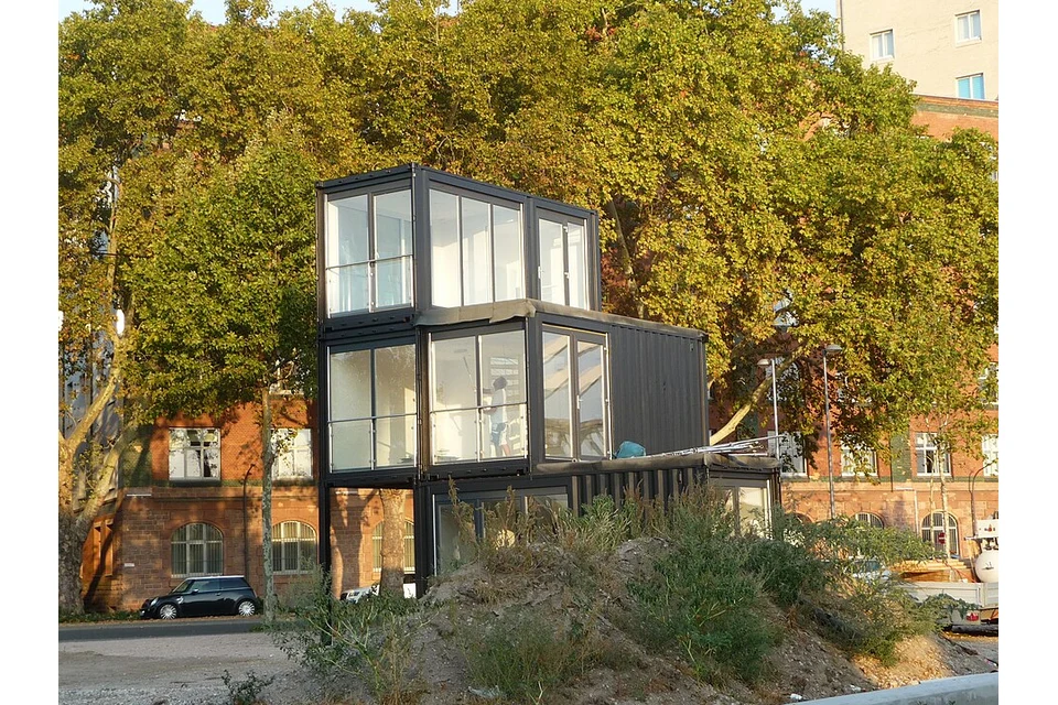Conjunto modular de contentores escritório ligados, com várias portas e janelas.