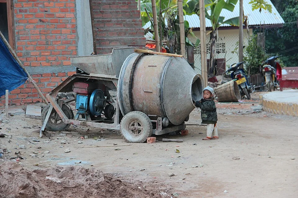Betoneira de obra com tambor giratório e chassis sobre rodas.