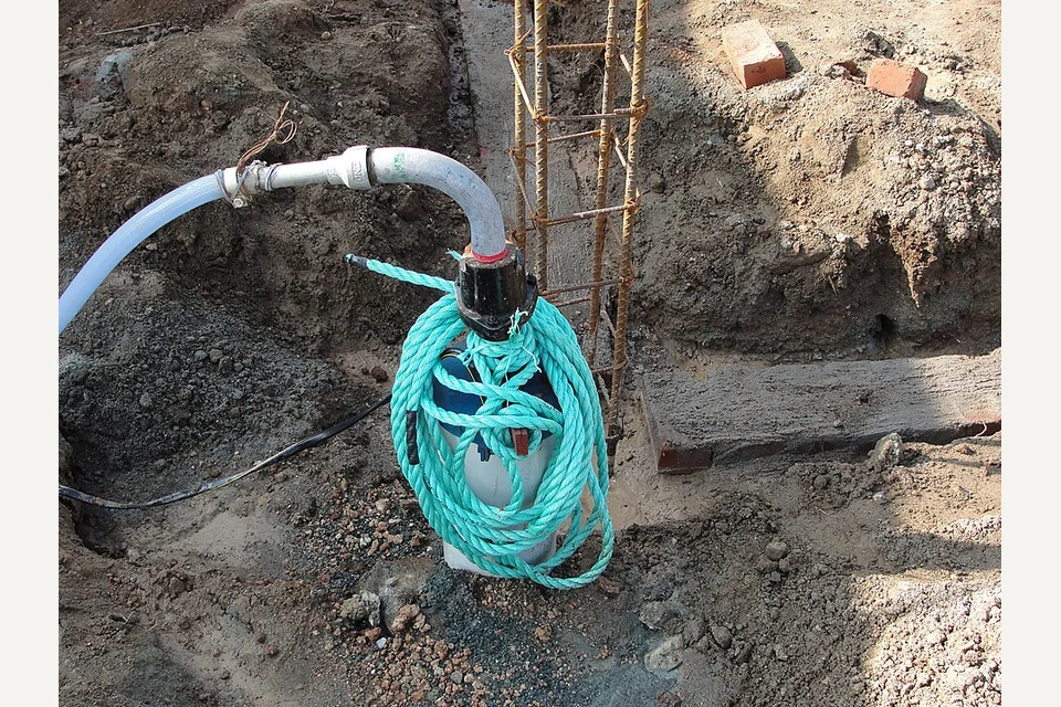 Bomba submersível de drenagem suspensa numa escavação