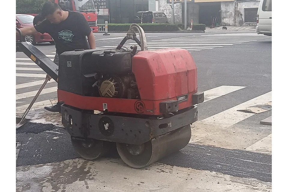 Cilindro pedonal de dois rolos, conduzido por um operador a pé.