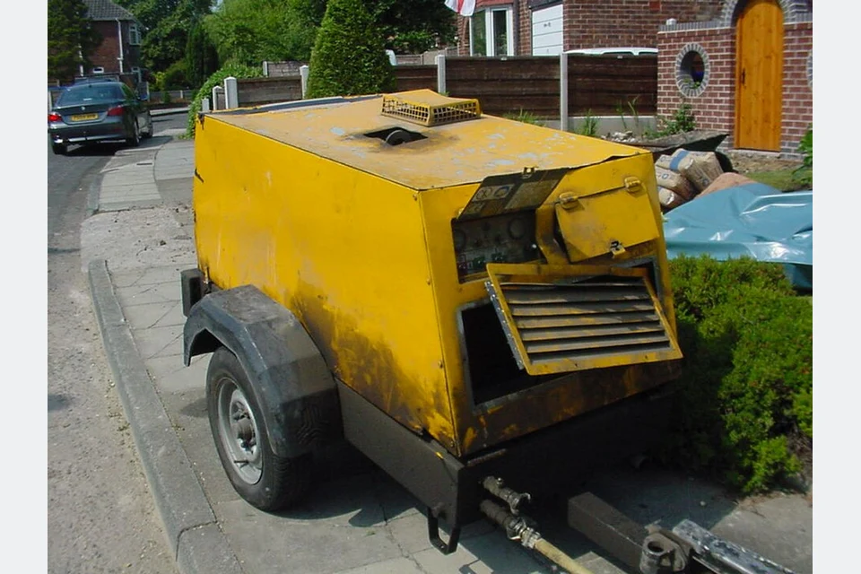 Compressor de ar amarelo rebocável para ferramentas pneumáticas.