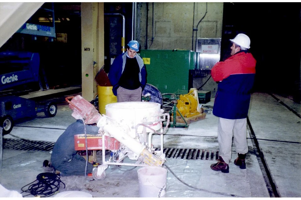 Máquina Putzmeister de bombear e projetar argamassa, com tremonha e mangueira.