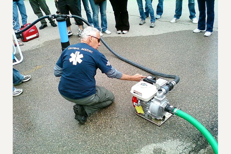 Motobomba portátil com motor a gasolina e mangueiras numa demonstração