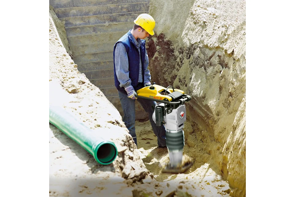 Saltitão Wacker Neuson BS 60-2i a compactar o solo numa vala.